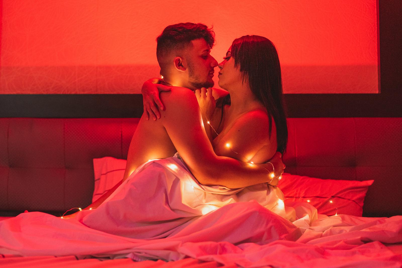 Couple embracing on a bed in warm light
